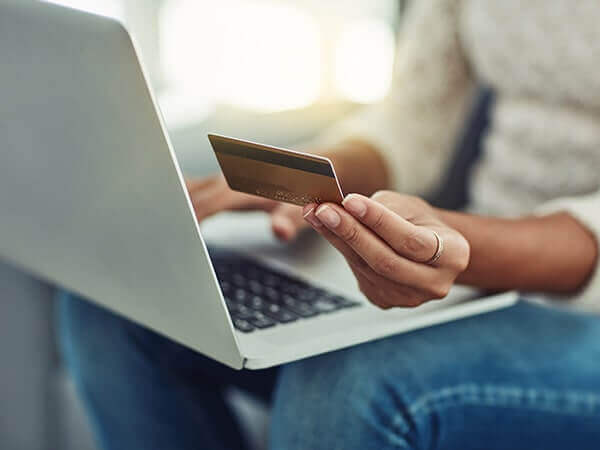 Woman holding credit card and laptop