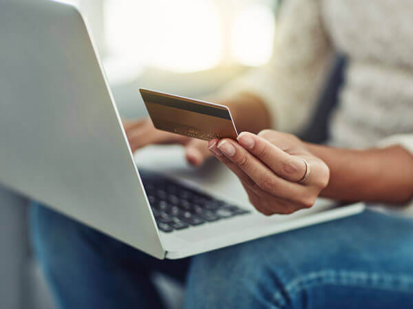image of person with laptop looking at credit card