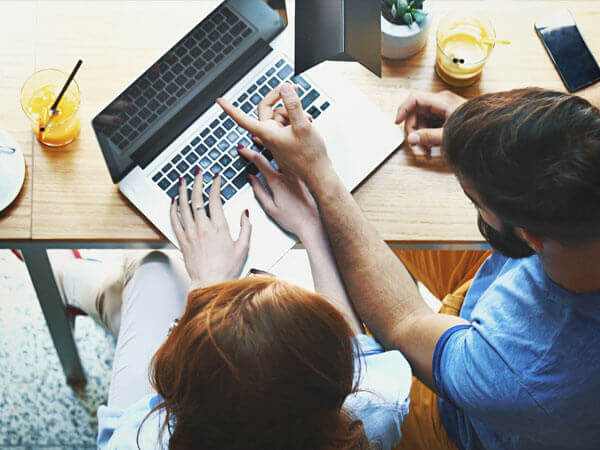 image of couple typing on laptop