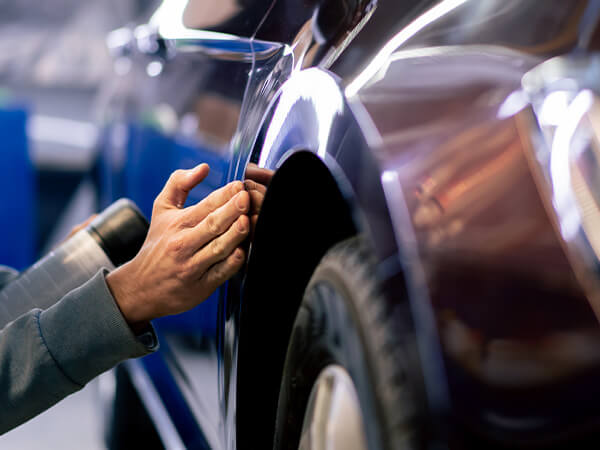 Person fixing small dent on car