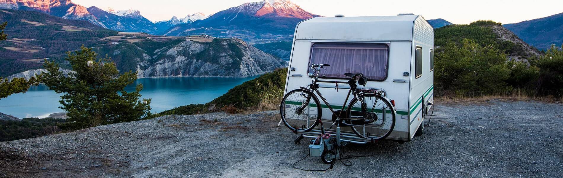 image of camper by water and mountains