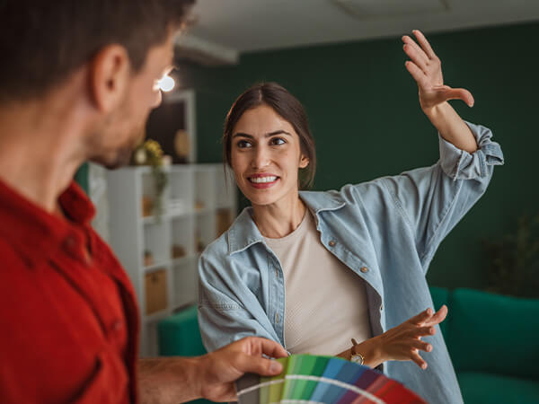 Woman choosing wall paint color with Home Improvement loan from UHCU