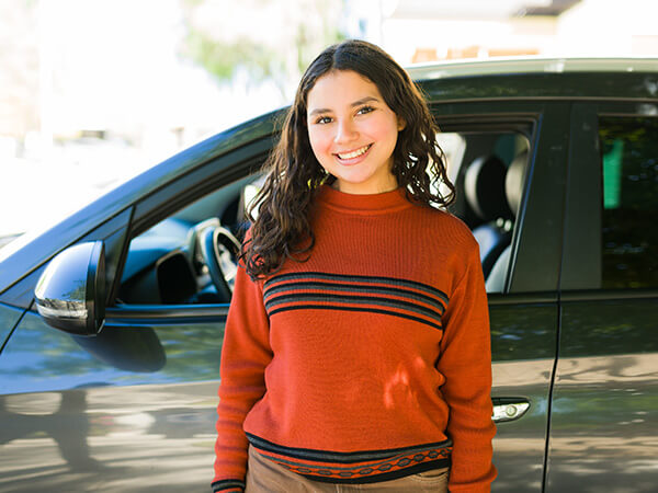 Young woman happy in front of car