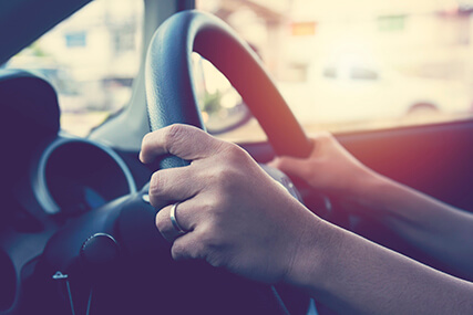 hands on steering wheel of car